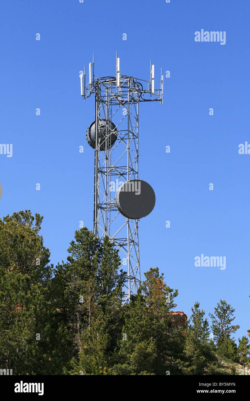Microondas y torres de antenas celulares en la cima de una colina Foto de stock