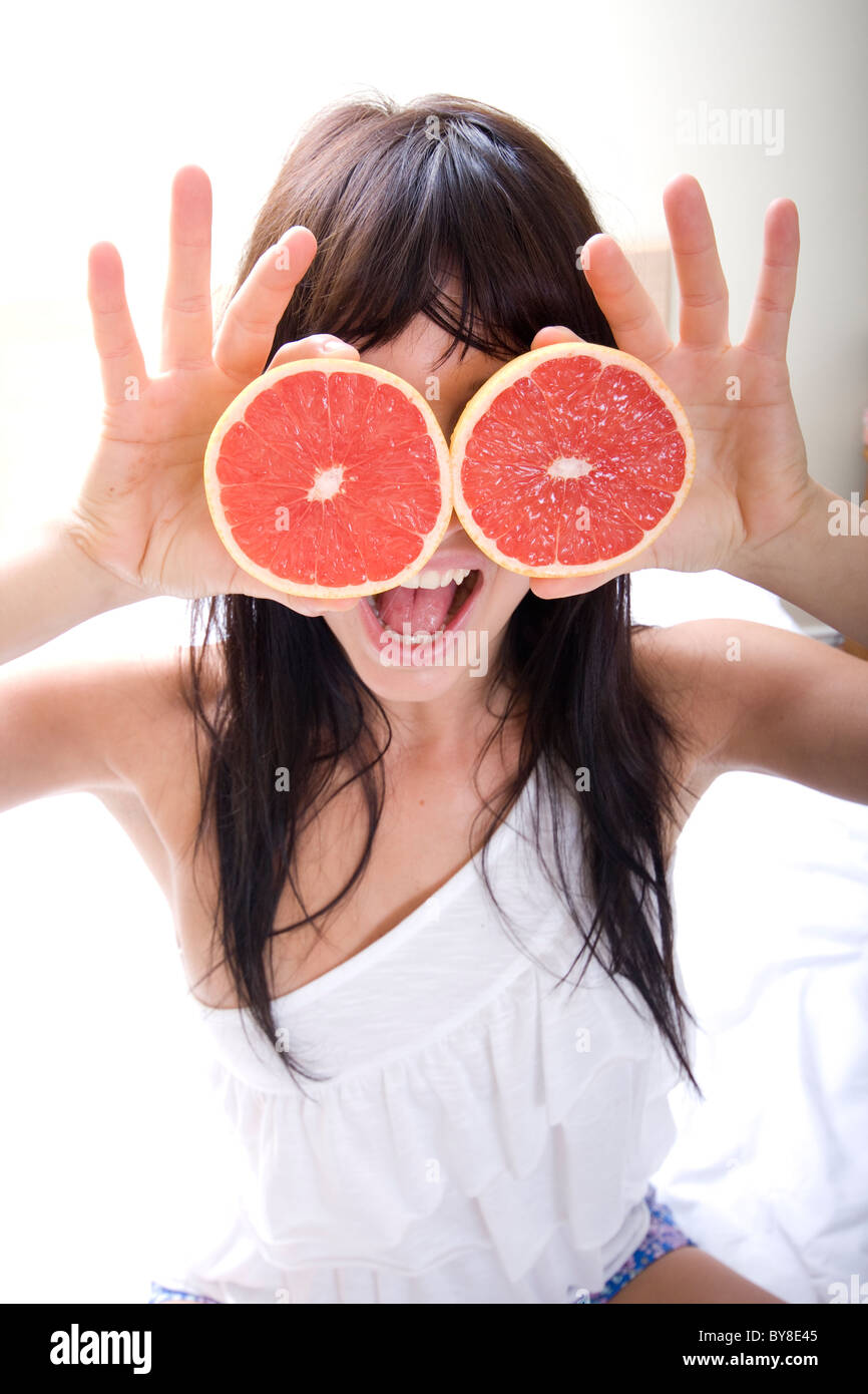 Cerca de la joven mujer atractiva jugando con pomelo Foto de stock