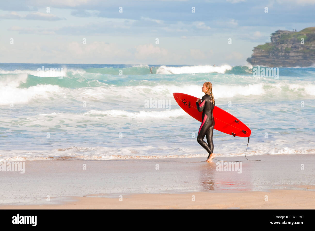 Surfer femenina entra en las olas en la playa de Bondi, en Sydney, Australia Foto de stock