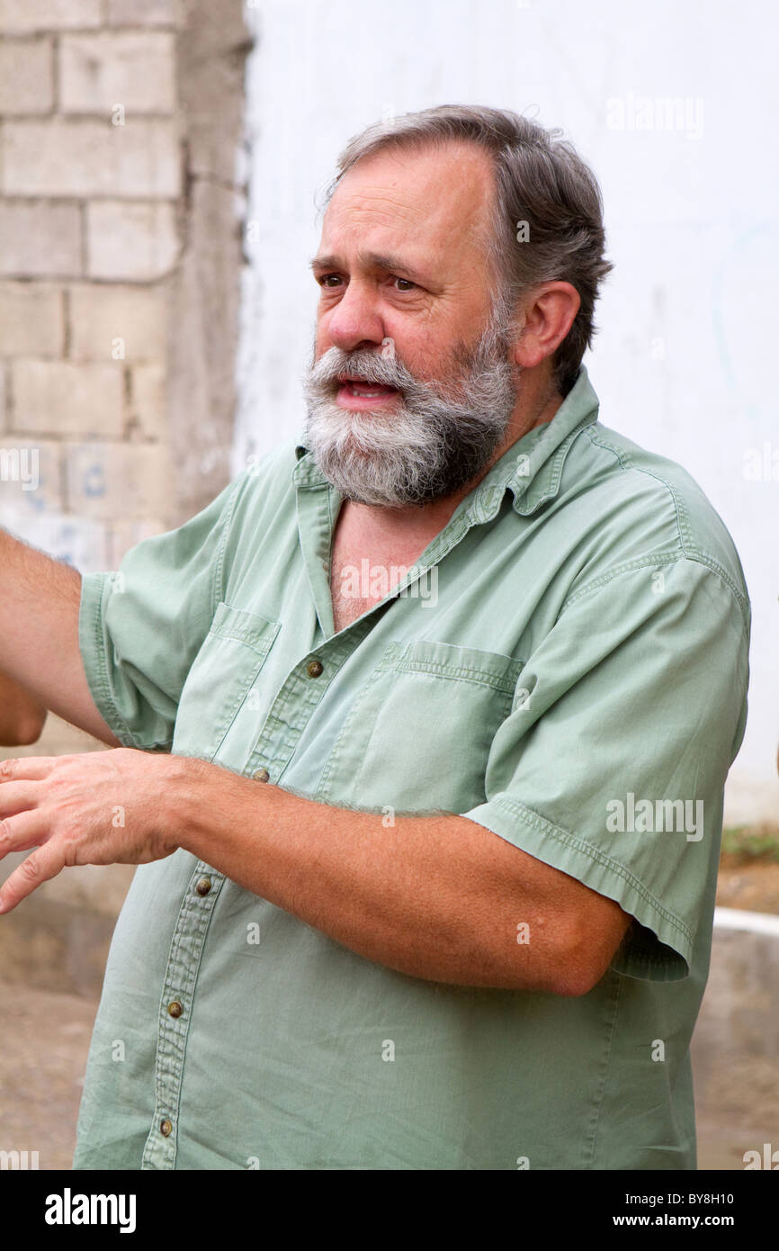 Hombre maduro, con barba gris gestos y comunicarse por medio de conversaciones y con sus manos. Foto de stock