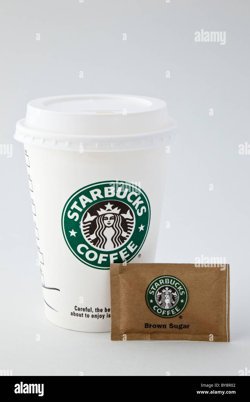 Starbucks Coffee Cup de papel desechables para llevar takeout con copa de plástico a través de la tapa y un sobrecito de azúcar moreno. Inglaterra Gran Bretaña Foto de stock