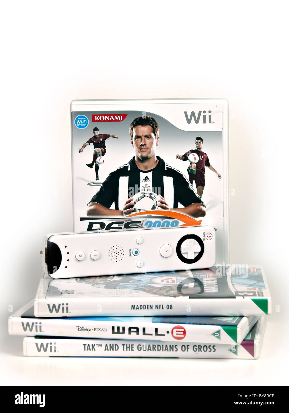 Juegos de Nintendo Wii y un controlador de Wii sobre fondo blanco. Foto de stock