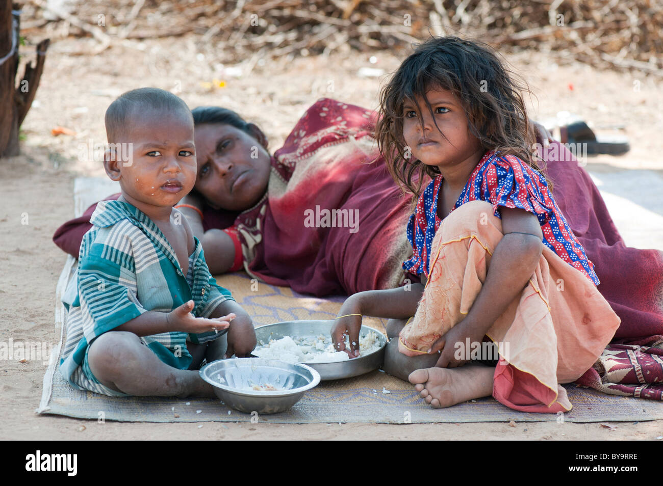 Pobre madre india de castas inferiores y los niños de comer arroz. En Andhra Pradesh, India Foto de stock