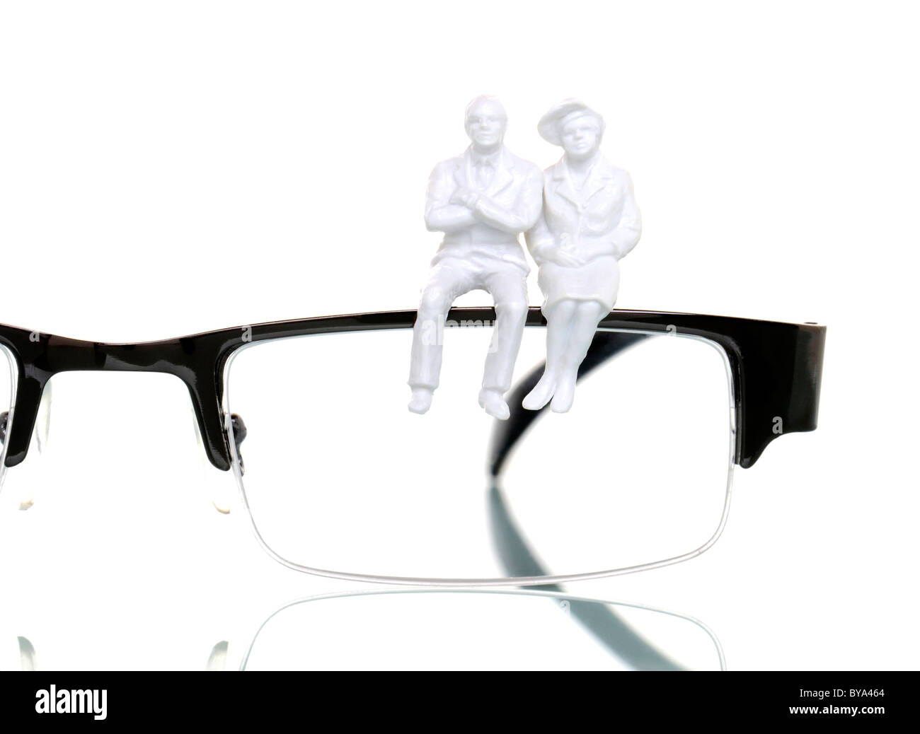 Dos figuras de jubilados sentados en un par de gafas, imagen simbólica Foto de stock