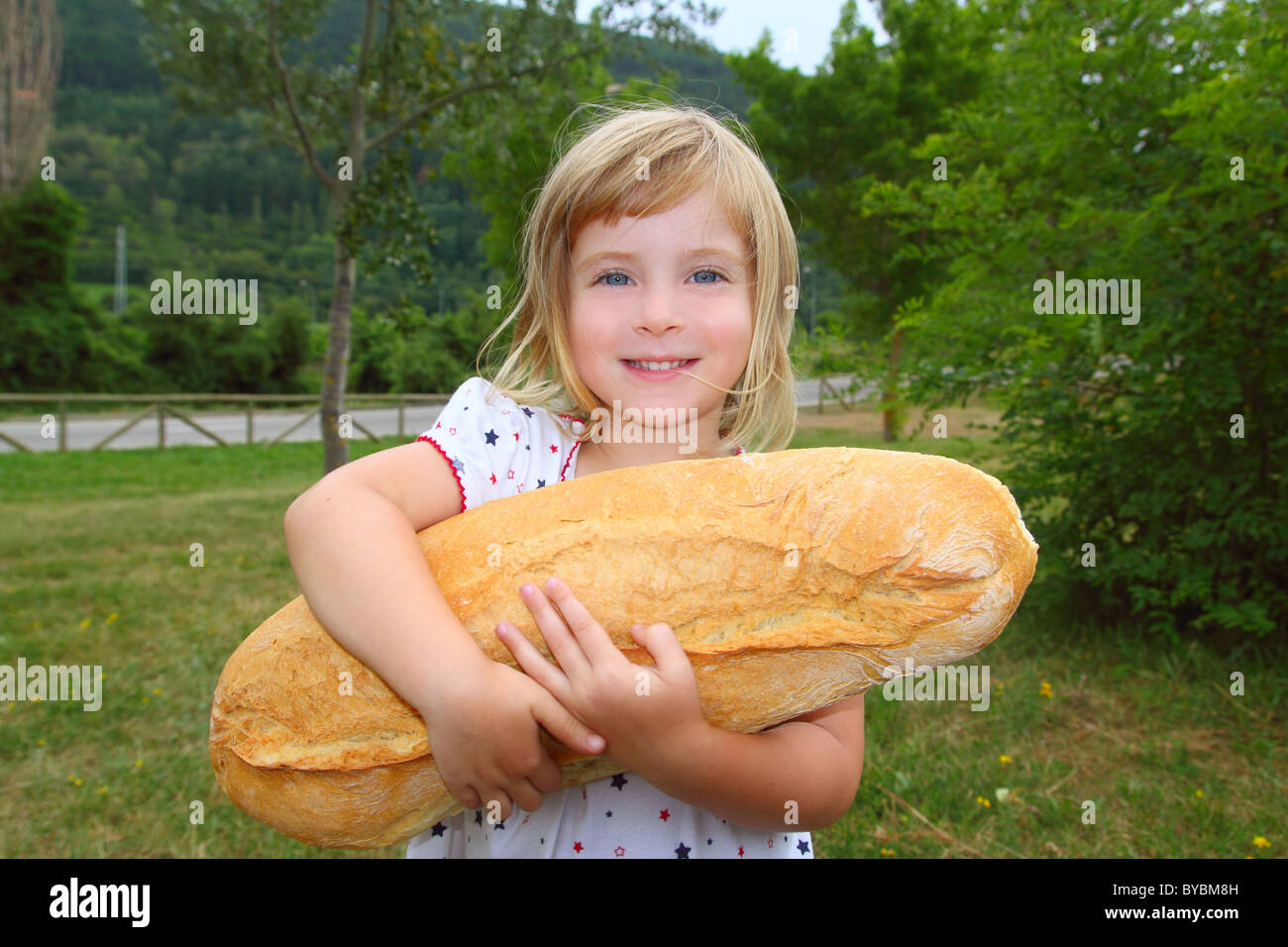 Chica sujetando grandes de pan de tamaño humor niño hambriento gesto gracioso Foto de stock