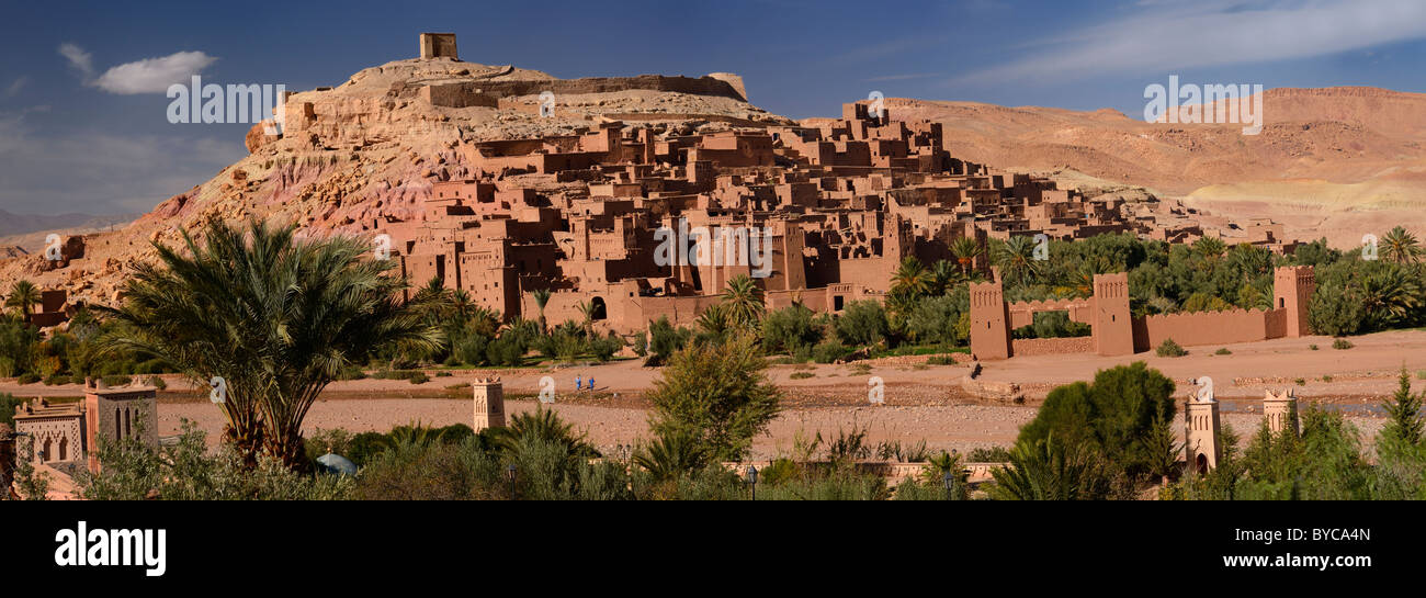 Panorama de la antigua fortaleza de la ciudad de Ait Benhaddou y bereberes azul cruzando Wadi Mellah, cerca de Ouarzazate Marruecos Foto de stock