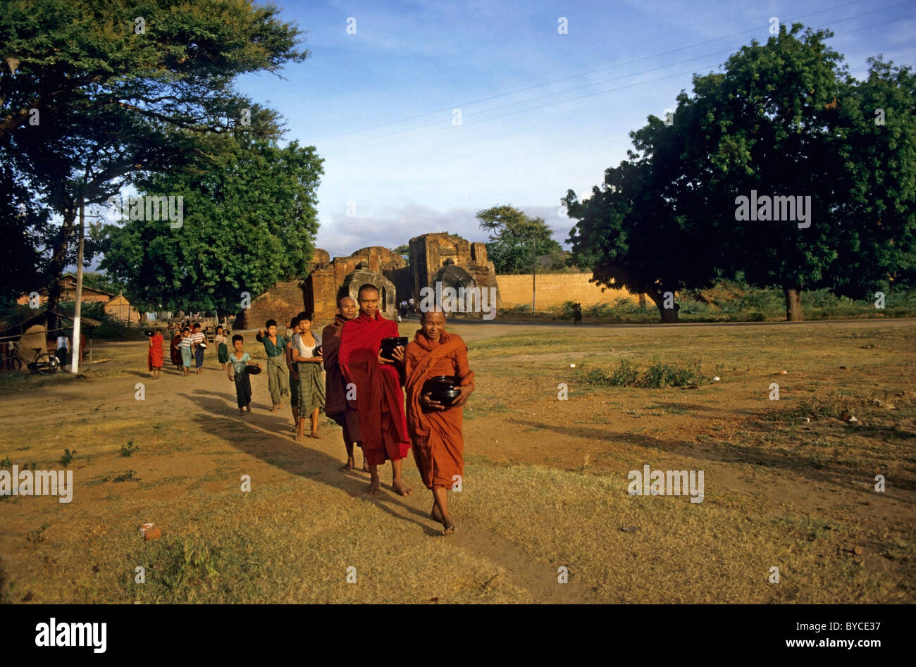 Los monjes budistas manteniendo sus frascos de comida en la mañana, Bagan, Birmania. Foto de stock