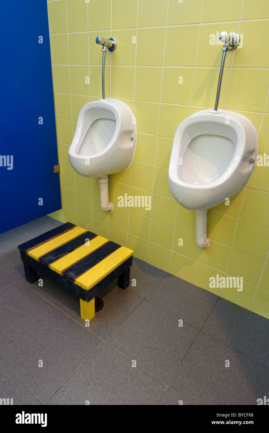 Los urinarios públicos con el paso para niños Foto de stock