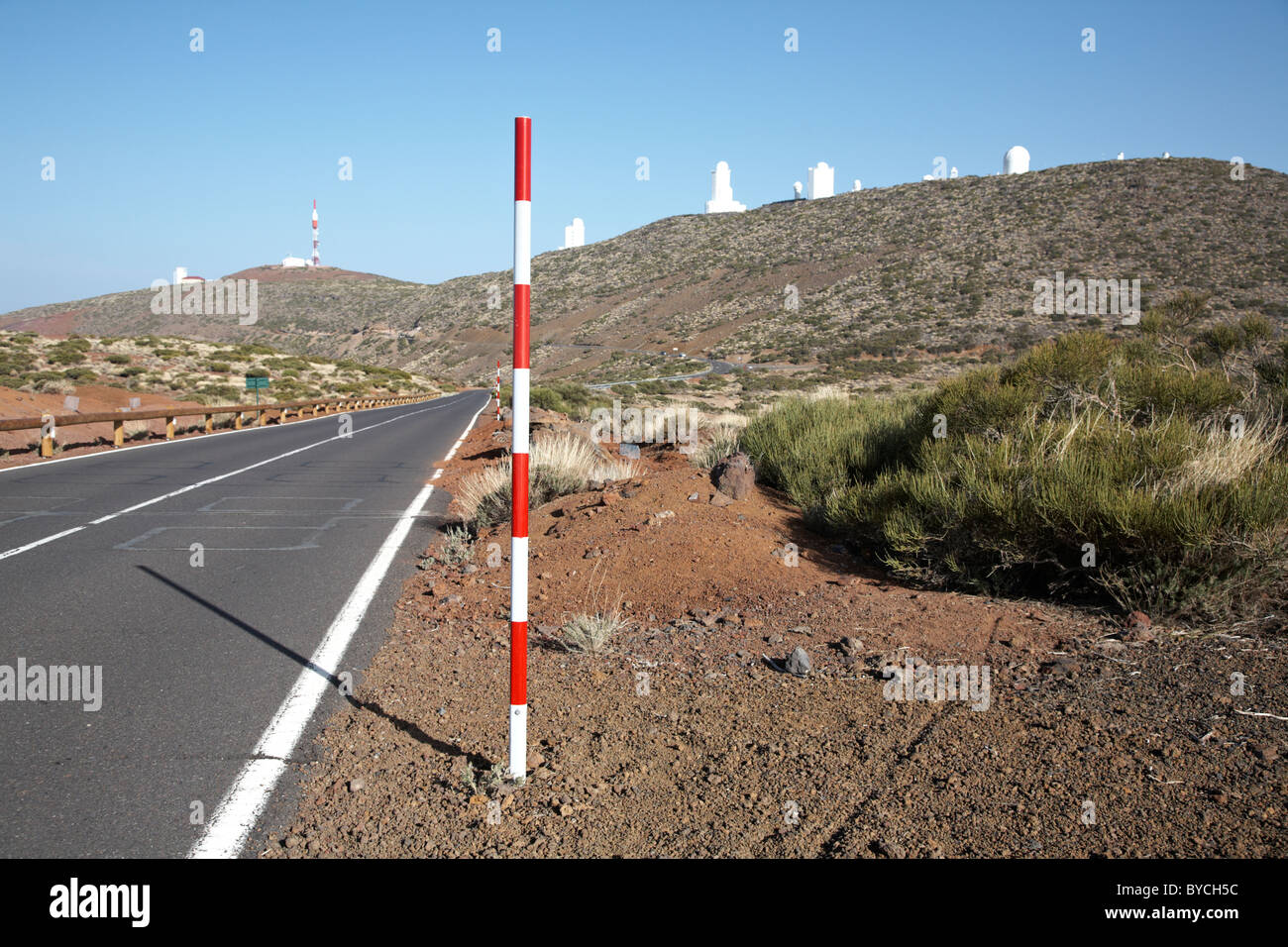 Rojo y blanco marcador de nivel de nieve en carretera al lado de la carretera en el Parque Nacional del Teide en Tenerife, Islas Canarias Foto de stock