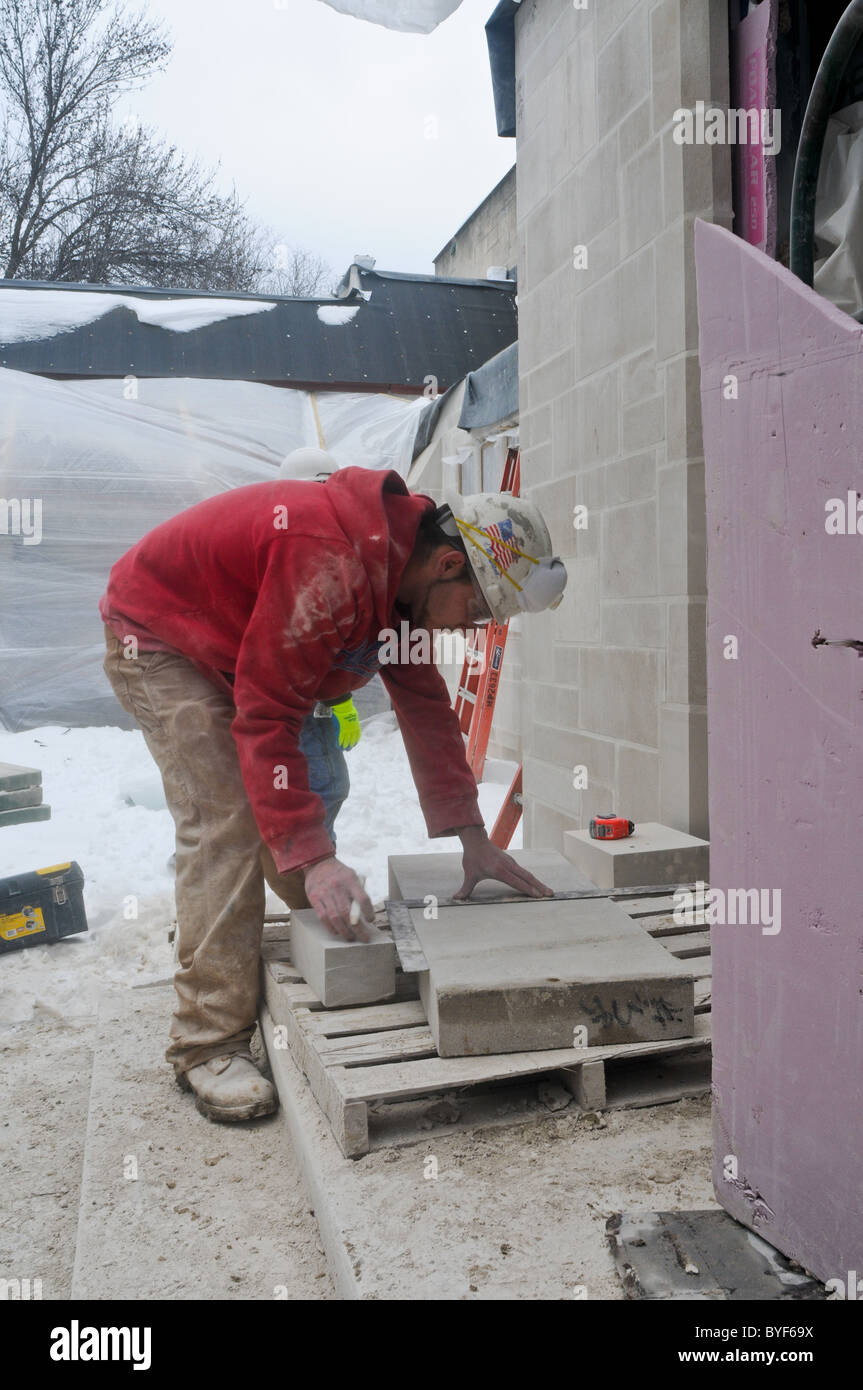 Invierno, trabajos de construcción con piedra cortada Foto de stock