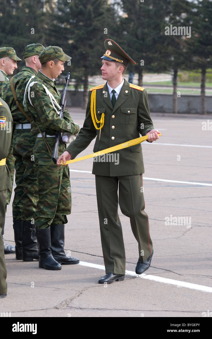 ULAN-EDA, Rusia - 9 de mayo: un desconocido joven oficial ruso camina por sus soldados sosteniendo una correa, antes del desfile en annua Foto de stock