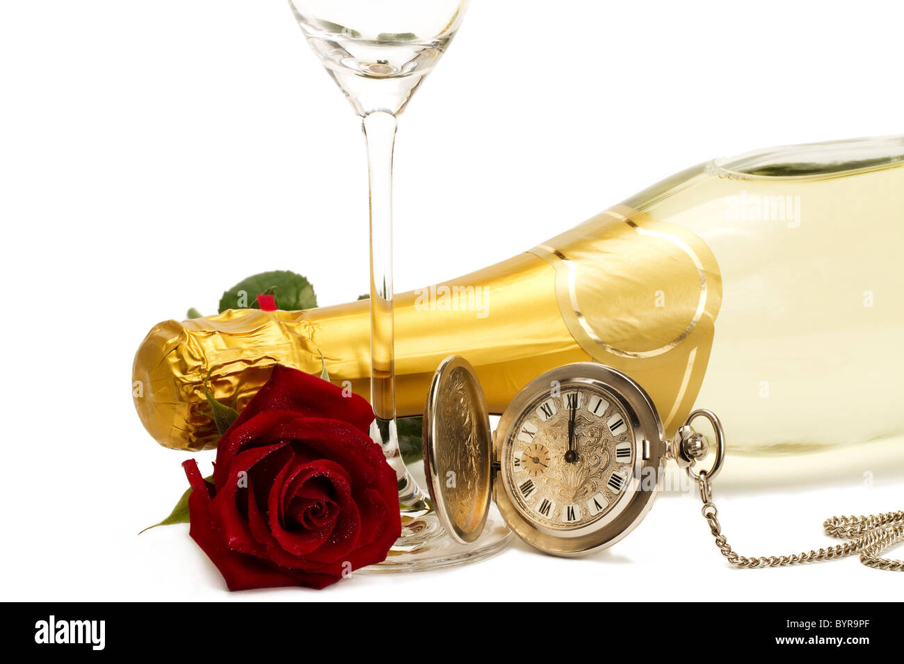 Rosa roja húmeda bajo una botella de champán con un viejo reloj de bolsillo y una copa de champán vacía sobre fondo blanco. Foto de stock