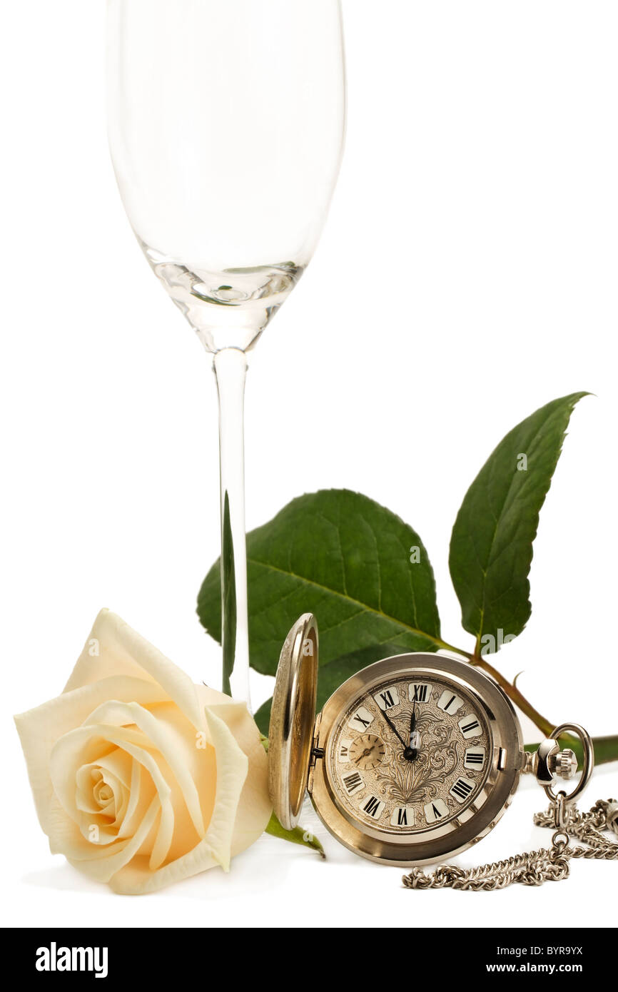 Rosa cremoso con un viejo reloj de bolsillo y una copa de champán vacía sobre fondo blanco. Foto de stock