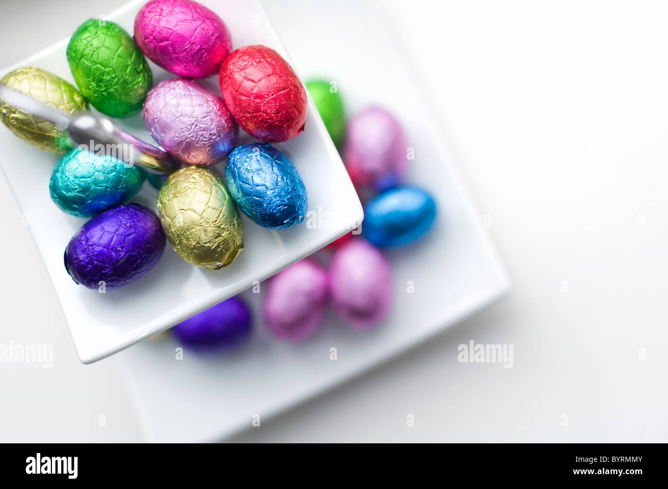 Una pequeña selección de mini huevos de chocolate en un plato blanco Foto de stock