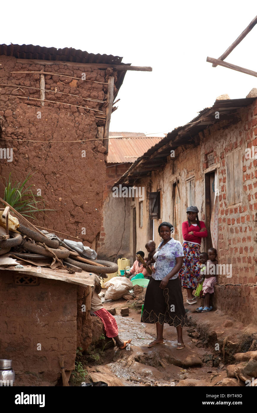 Los residentes están en un callejón de un barrio de tugurios en Kampala, Uganda, en el África oriental. Foto de stock