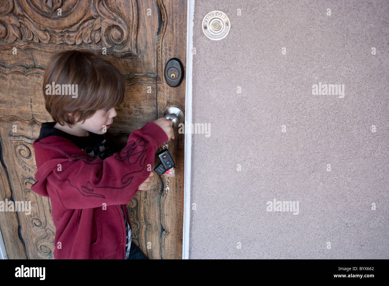 Desbloqueo del niño delante de su puerta con una llave Fotografía de stock  - Alamy