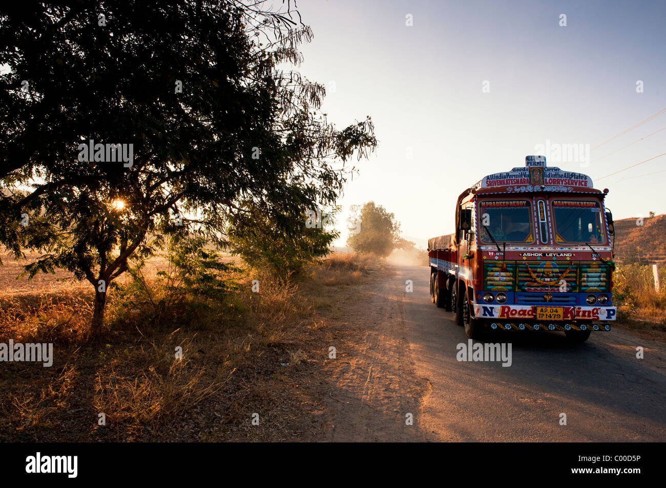 Camión de transporte India viajar a lo largo de una carretera en un amanecer en el campo indio. En Andhra Pradesh, India Foto de stock
