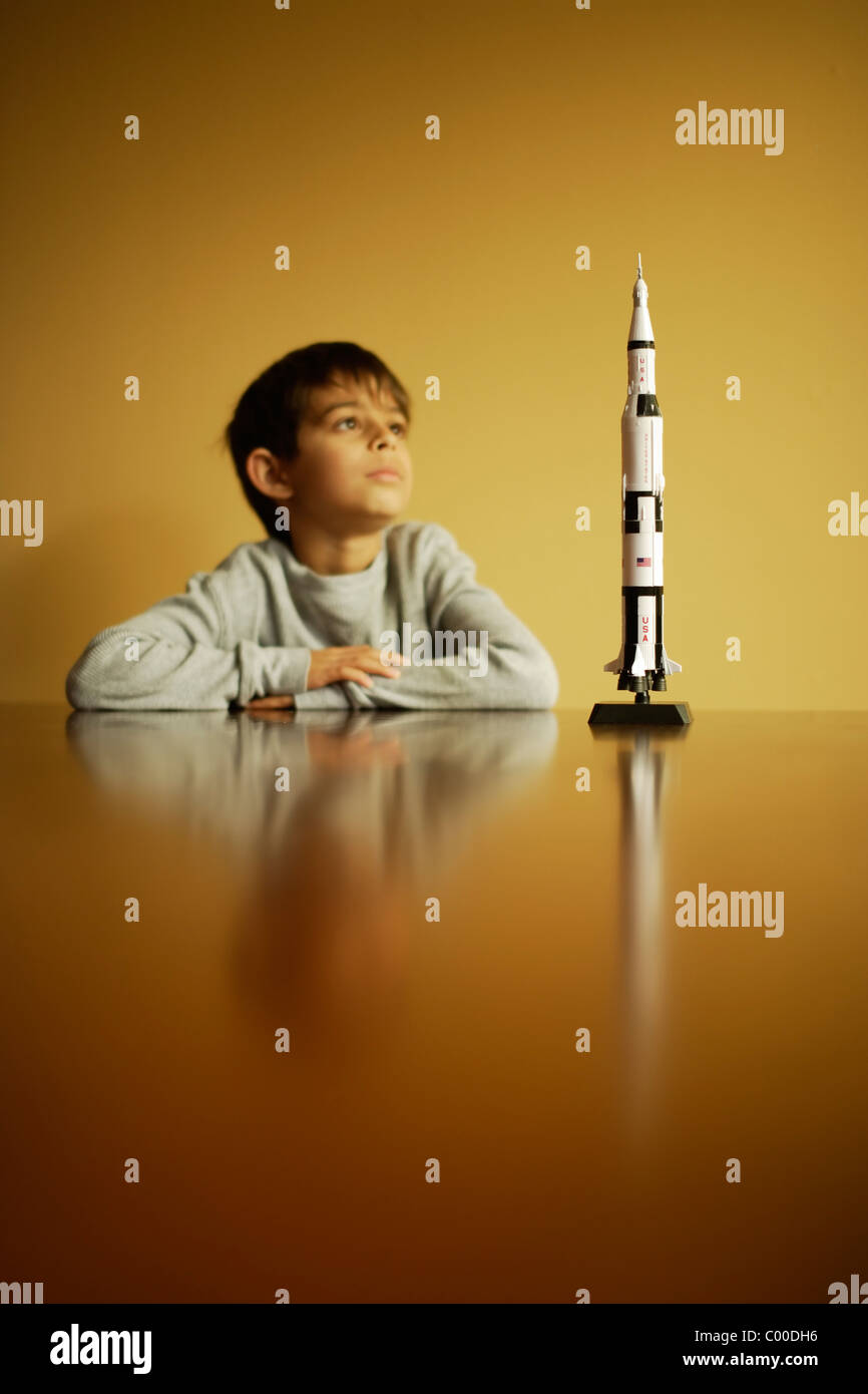 Niño con modelo Apollo moon cohete Saturno V Foto de stock