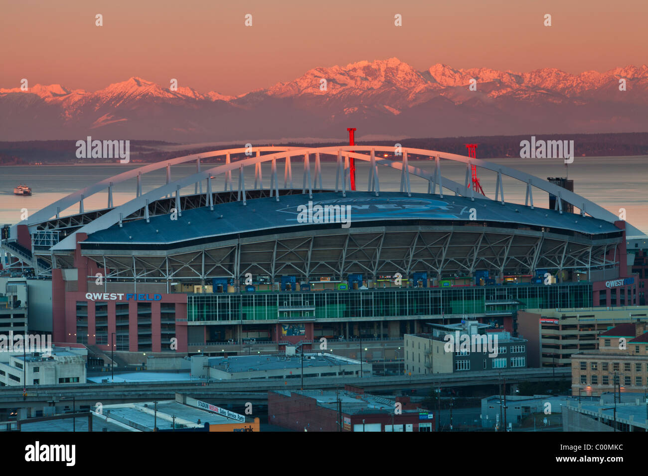 Qwest Field al amanecer como las lejanas montañas olímpicas están resaltadas con los primeros rayos del sol, Seattle, Washington. Foto de stock