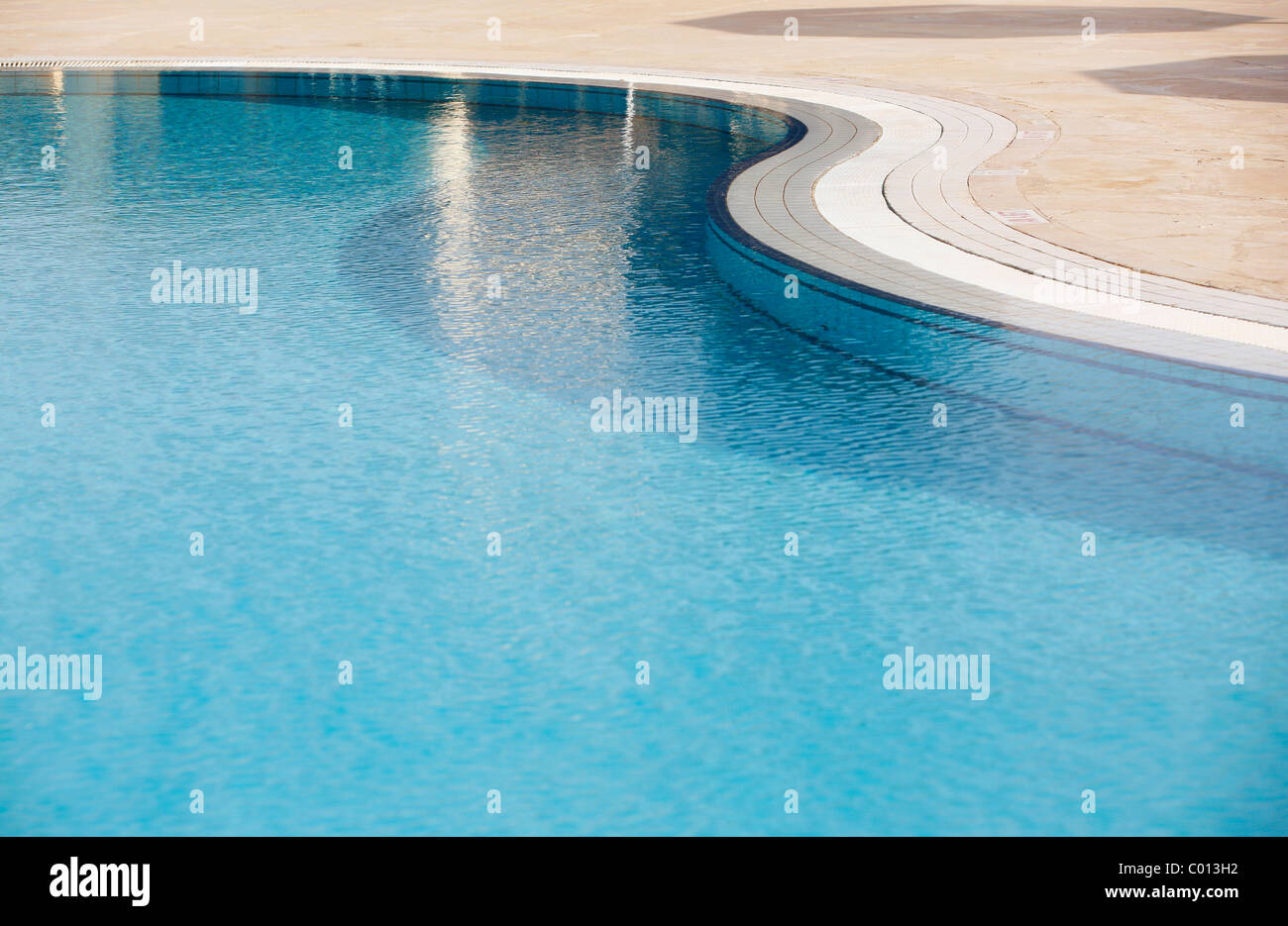 Superficie de agua ondulada en una piscina, detalle azul con pasos por debajo de la superficie Foto de stock