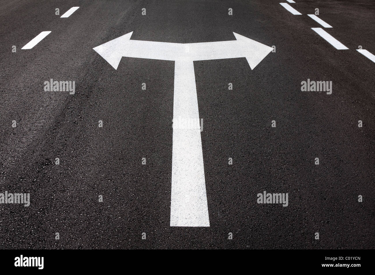 Las flechas de giro izquierdo y derecho pintado sobre asfalto de carretera. Concepto para girar, decisión, elección, de qué manera, a la derecha, a la izquierda. Foto de stock