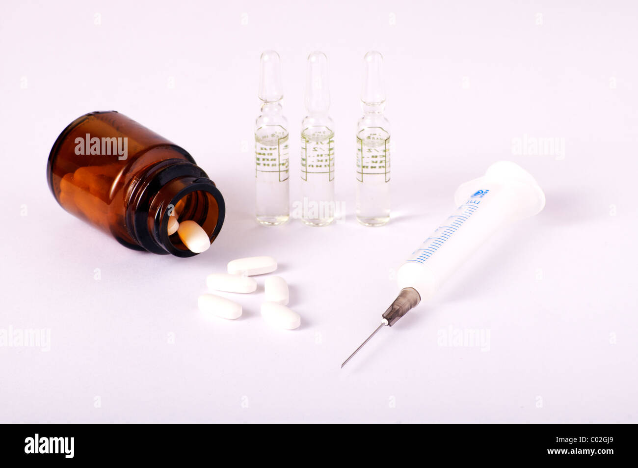 Jeringas, viales y un frasco con píldoras Foto de stock