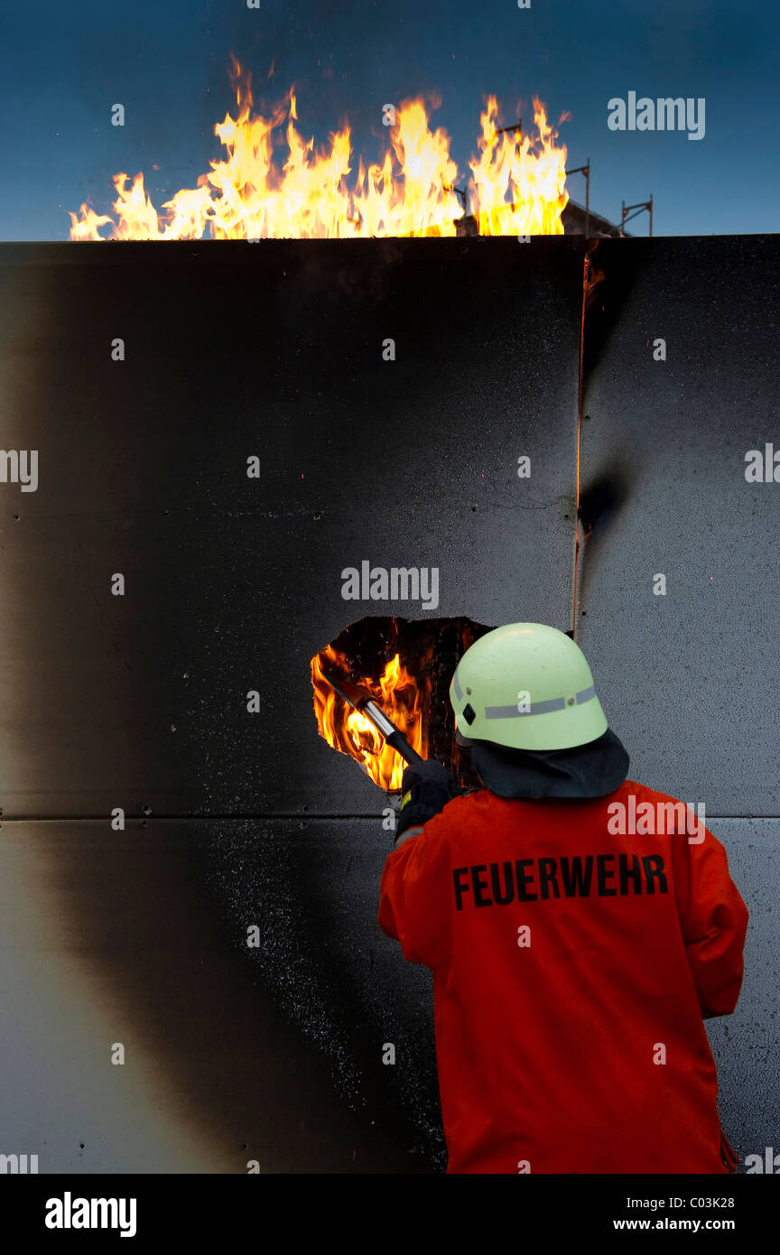 Fireman delante de una pared ardiente Foto de stock