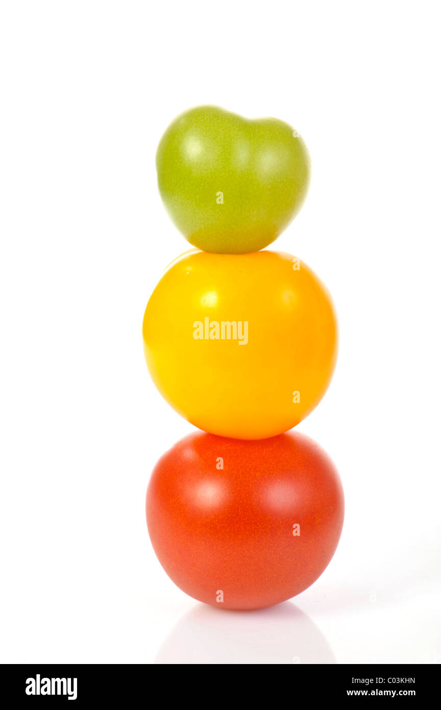 Diferentes tomates apiladas, de colores rojo, amarillo y verde Foto de stock