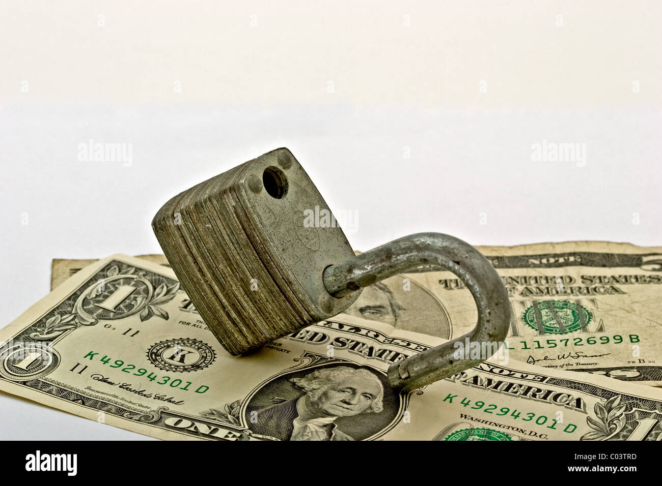 Los billetes de dólar americano en un candado abierto Foto de stock