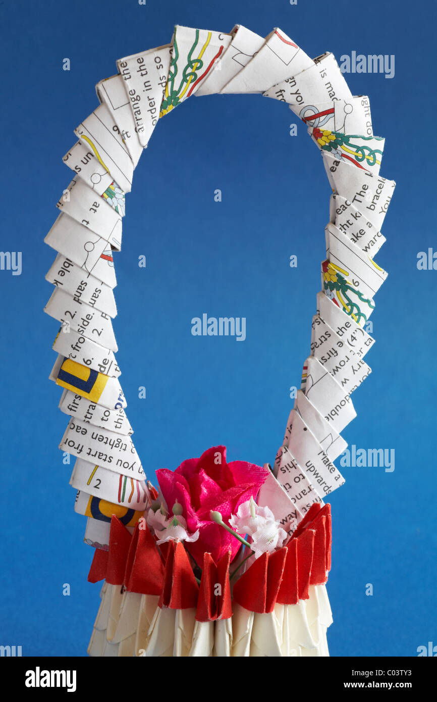 Origami canasta de flores con fondo azul. Foto de stock