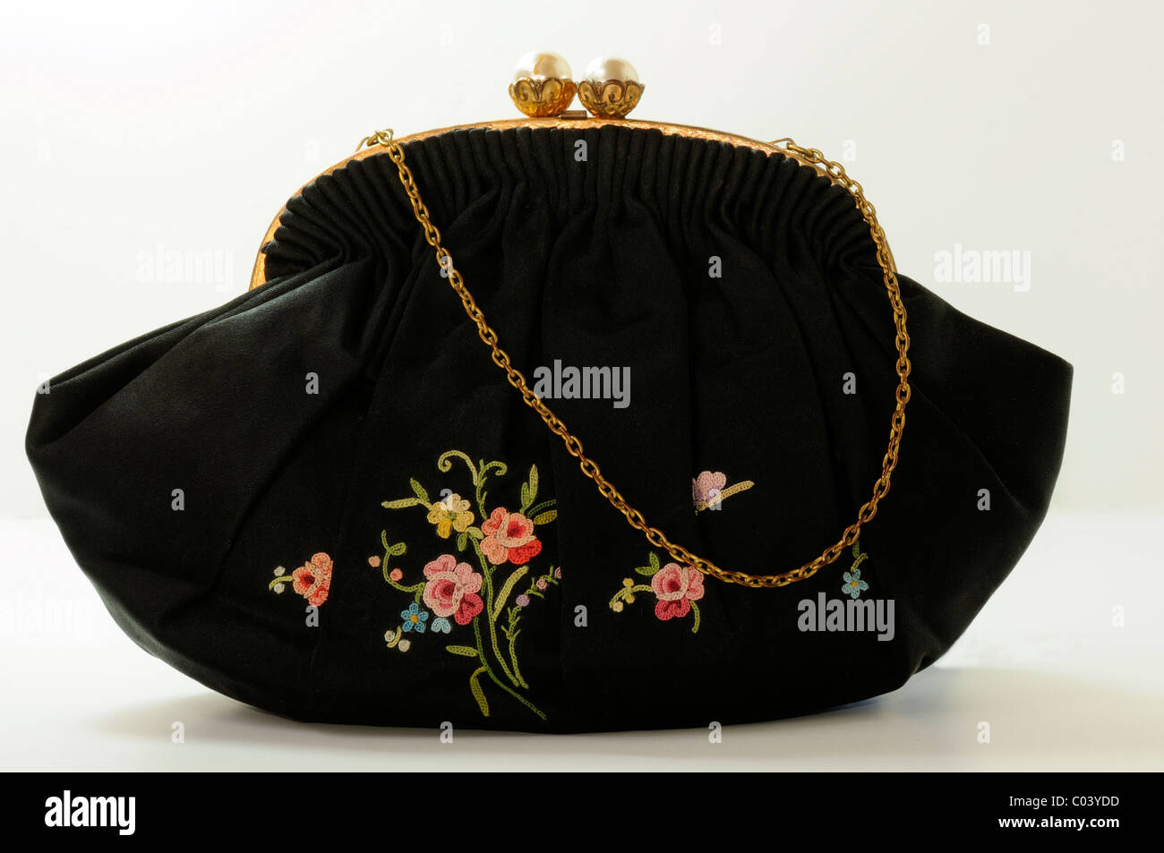 Vintage lady's negro pequeño bolso de tela con flores bordadas y cadena de  metal aparecen sobre un fondo blanco Fotografía de stock - Alamy