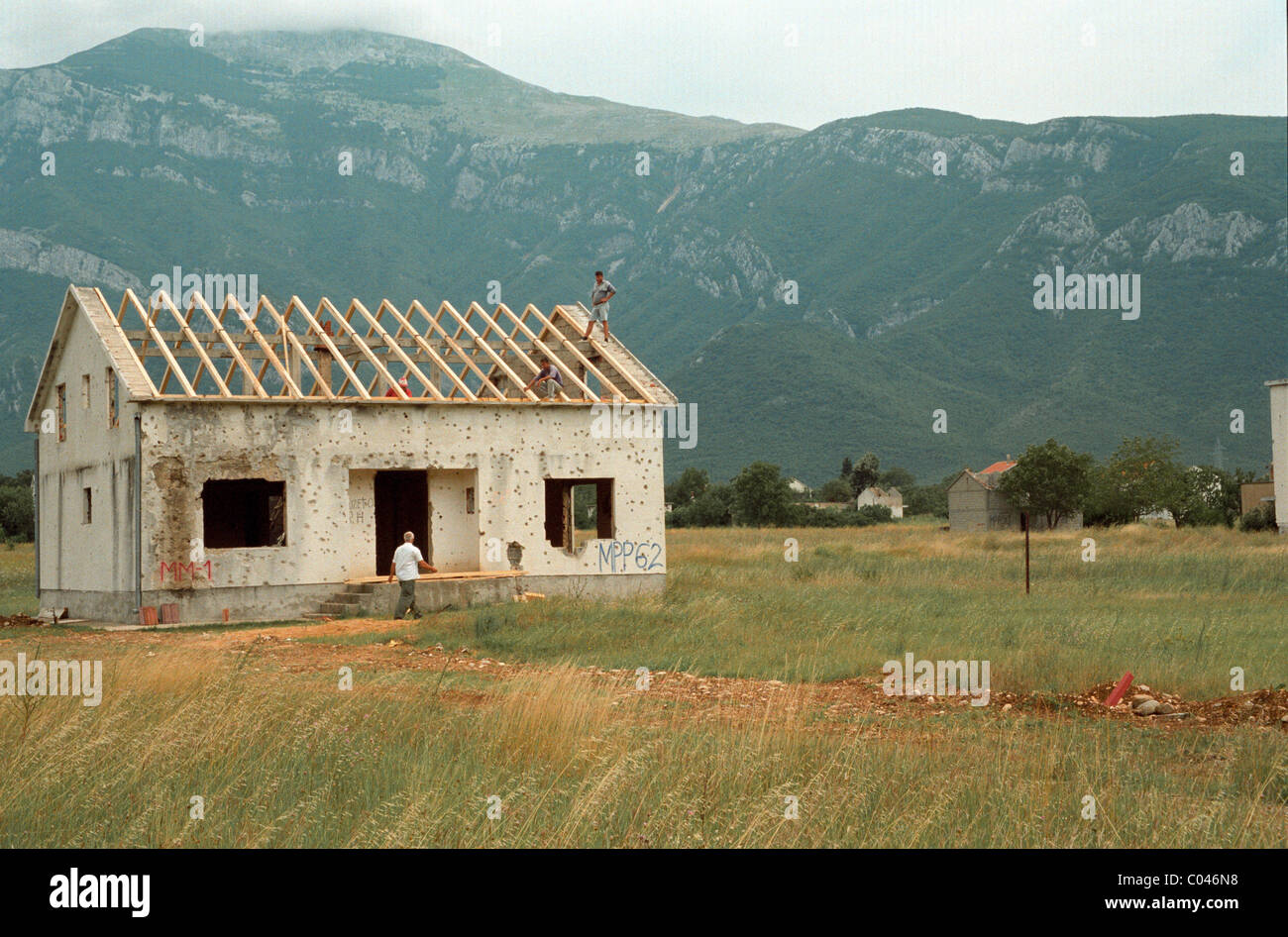 Constructores reconstruir una casa cerca de Mostar en Bosnia que había sido destruida durante la guerra civil Foto de stock