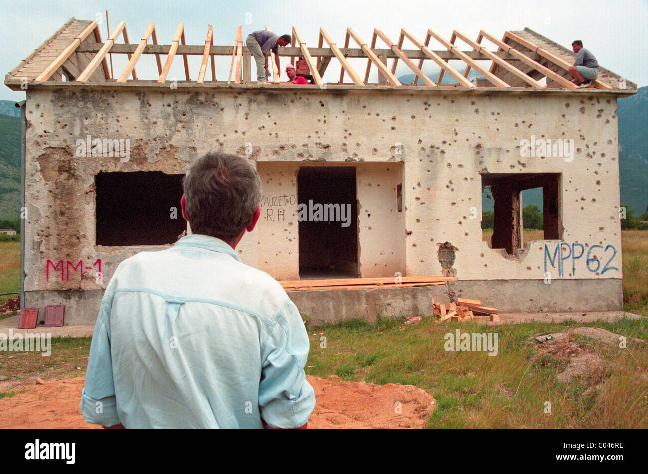 Constructores reconstruir una casa cerca de Mostar en Bosnia que había sido destruida durante la guerra civil Foto de stock