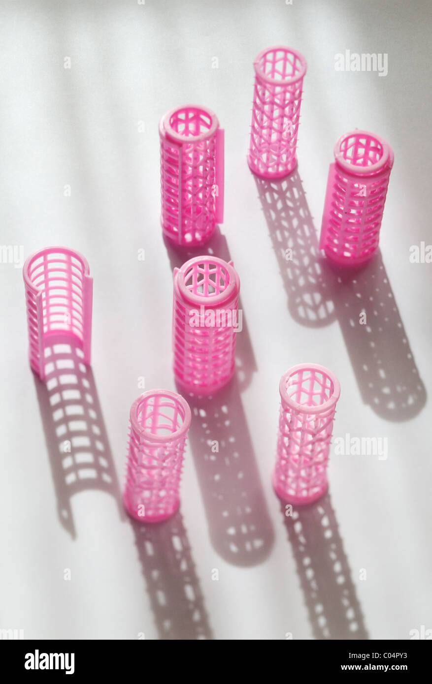 Rizadores de plástico rosa con sombras largas Foto de stock