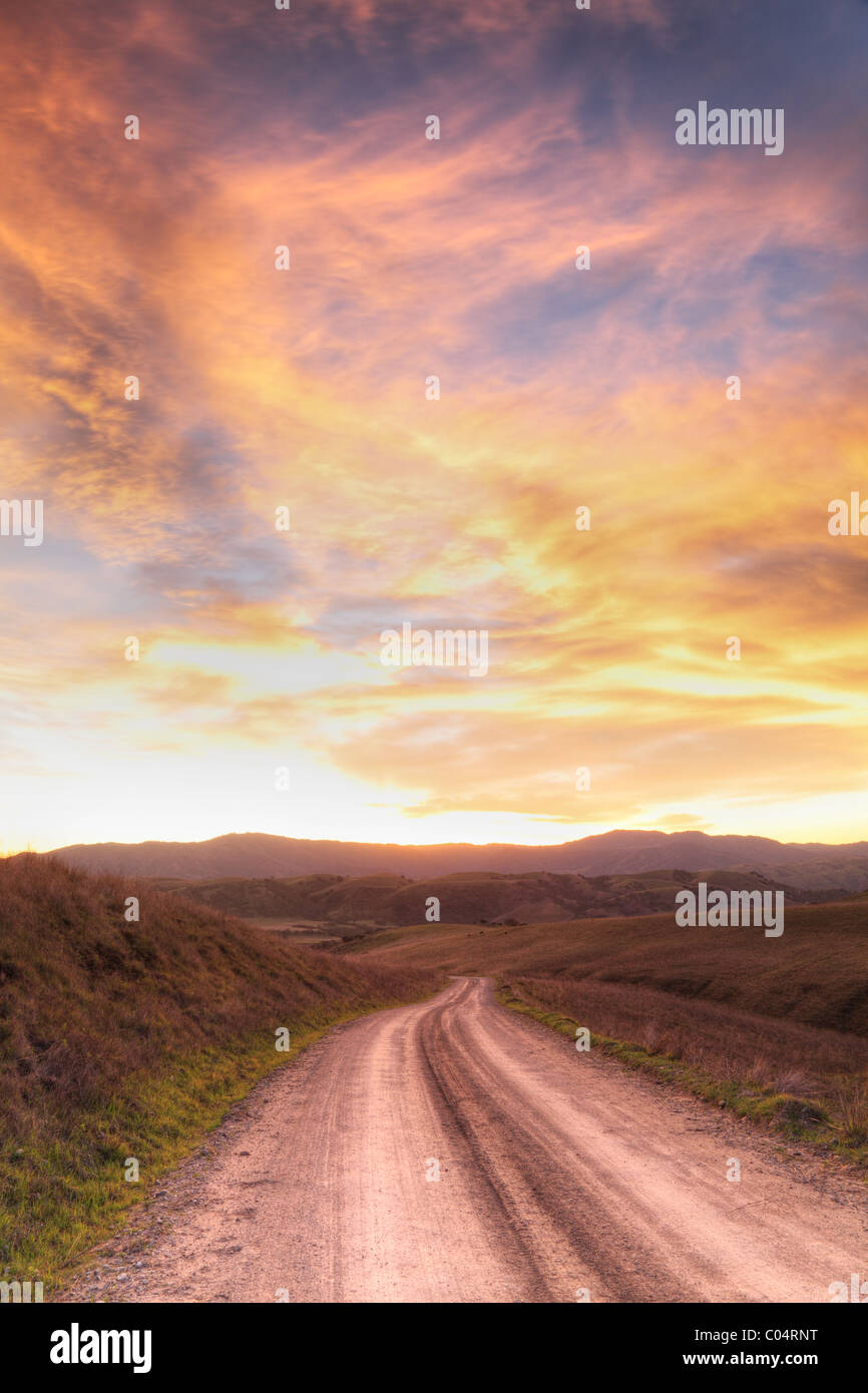 Un espectacular cielo enciende una carretera rural Foto de stock