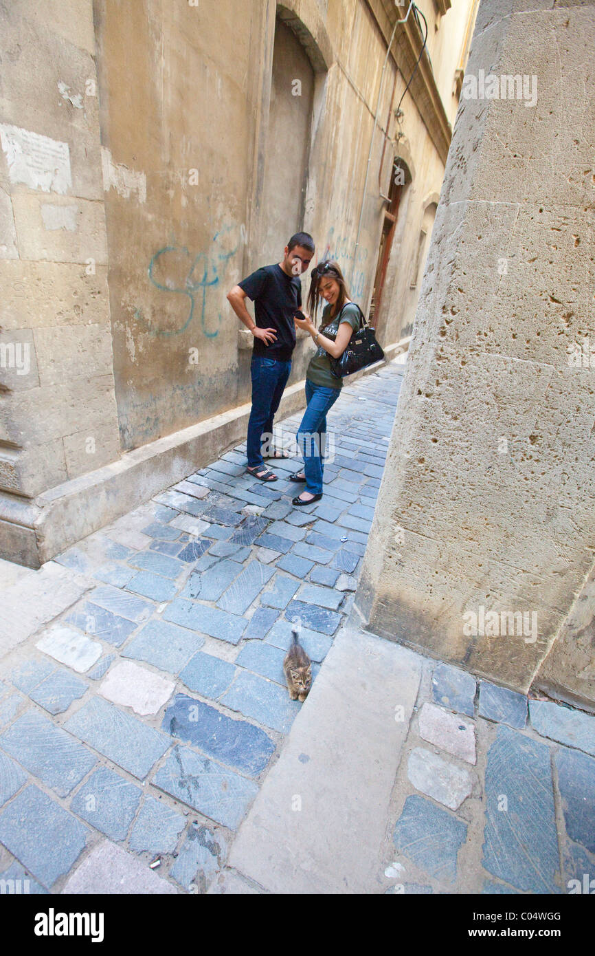 Joven pareja local en un estrecho callejón en el casco antiguo de la ciudad de Baku, Azerbaiyán. Foto de stock