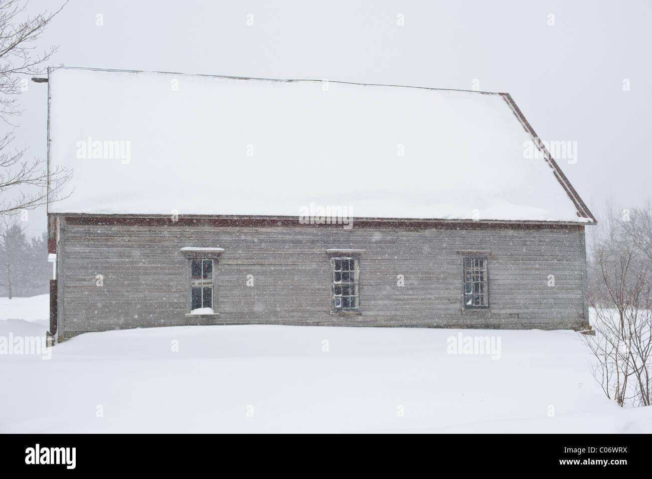 Capeado graneros en invierno tormenta de nieve en el este de Canadá Foto de stock