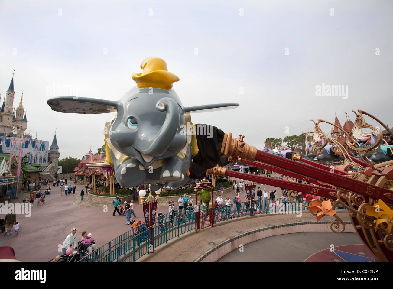 Dumbo the Flying Elephant es un viaje al Reino Mágico de Disney World en Orlando, Florida. Cinderella Castle puede verse en la espalda. Foto de stock
