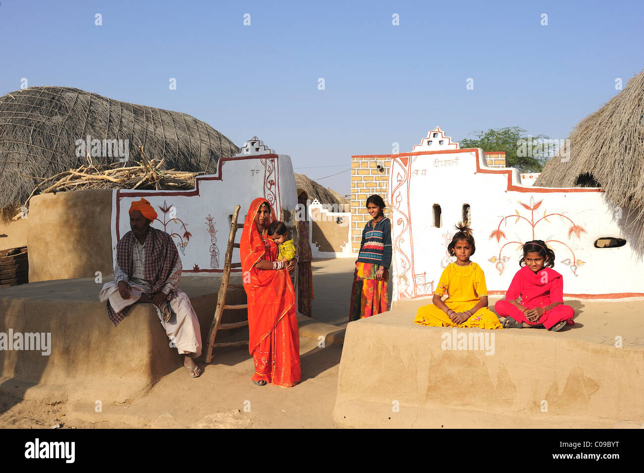 Una familia delante de la entrada pintada a su propiedad, el desierto de Thar, Rajastán, India, Asia Foto de stock