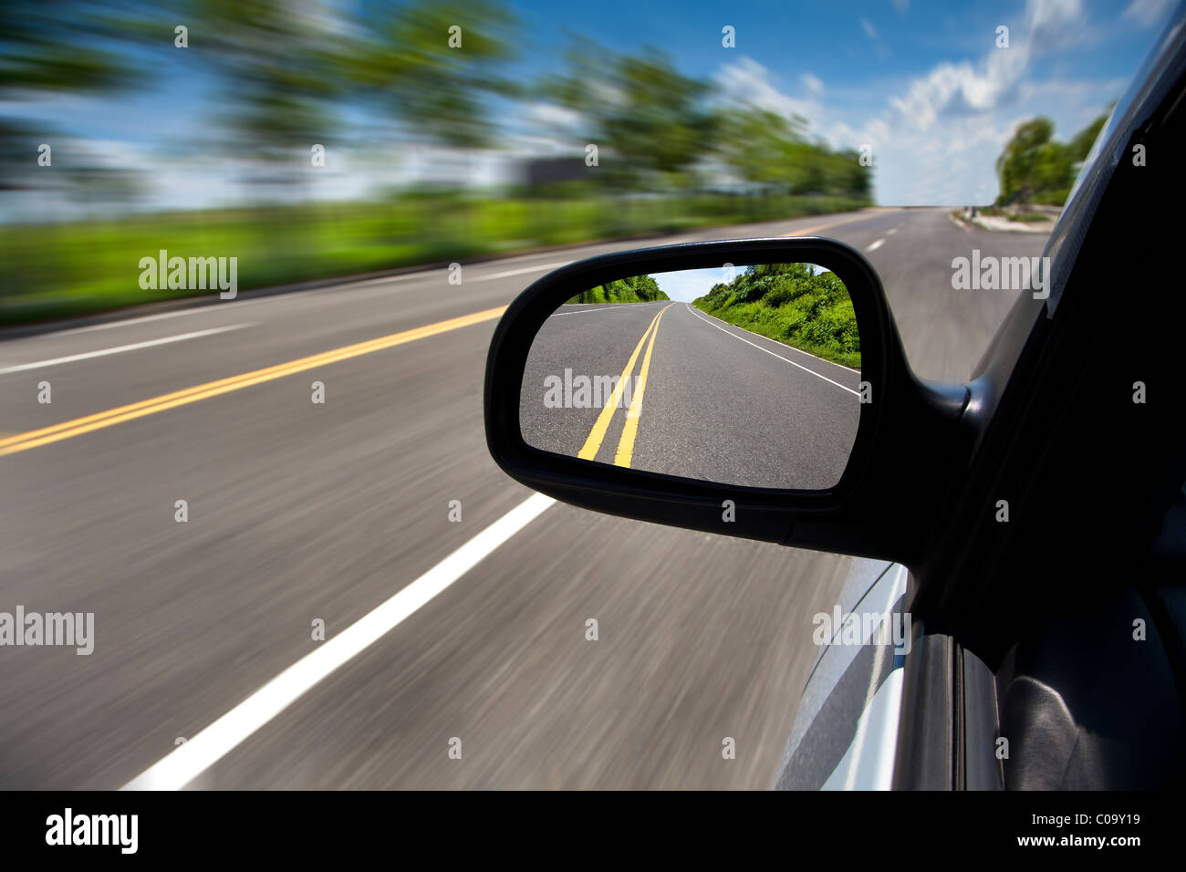 Coche de conducción a través de la carretera vacía y centrarse en el espejo Foto de stock