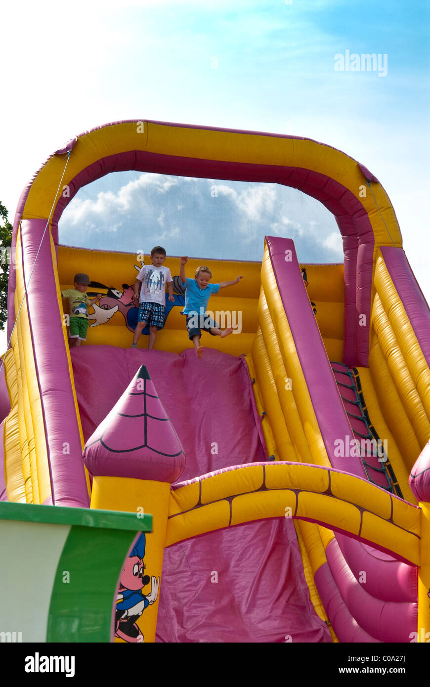 Niños jugando en el tobogán inflable y castillo hinchable Fotografía de  stock - Alamy