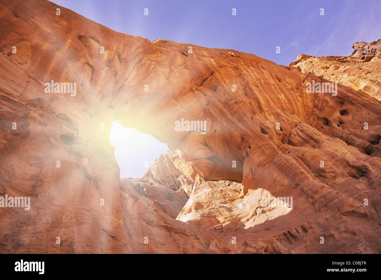 Arco erosivas naturales en los cerros de arenisca roja en el desierto Foto de stock