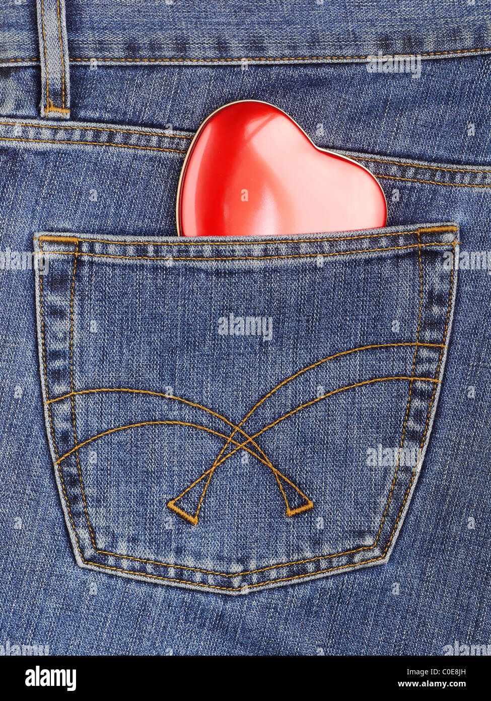 Corazón rojo sobresalen de blue jeans bolsillo posterior. Foto de stock