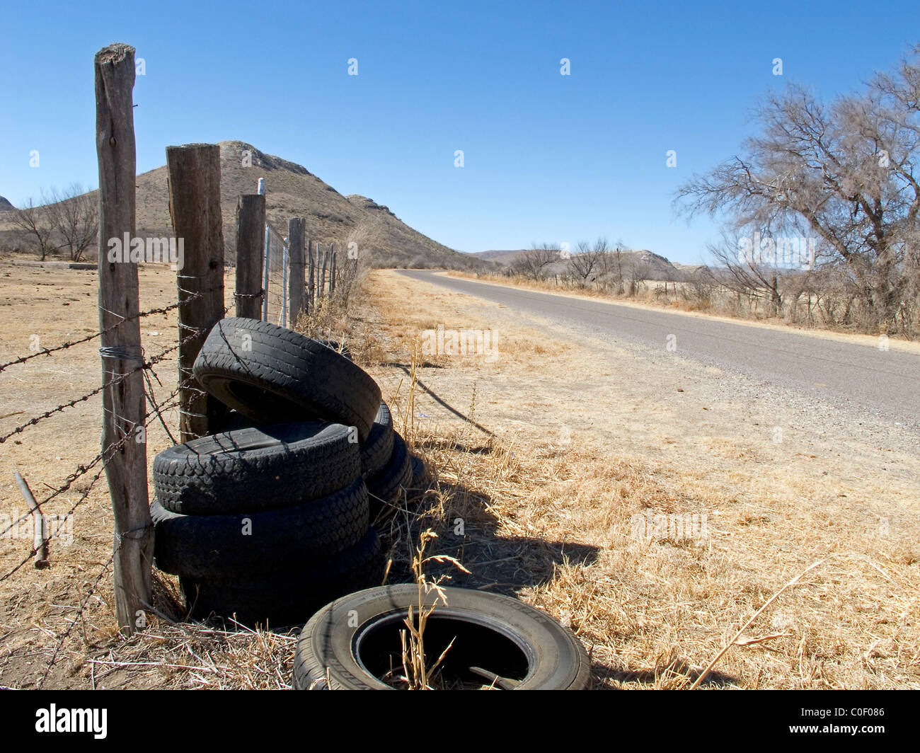 Neumáticos viejos desechados a lo largo de una carretera rural en el oeste  de Texas Fotografía de stock - Alamy
