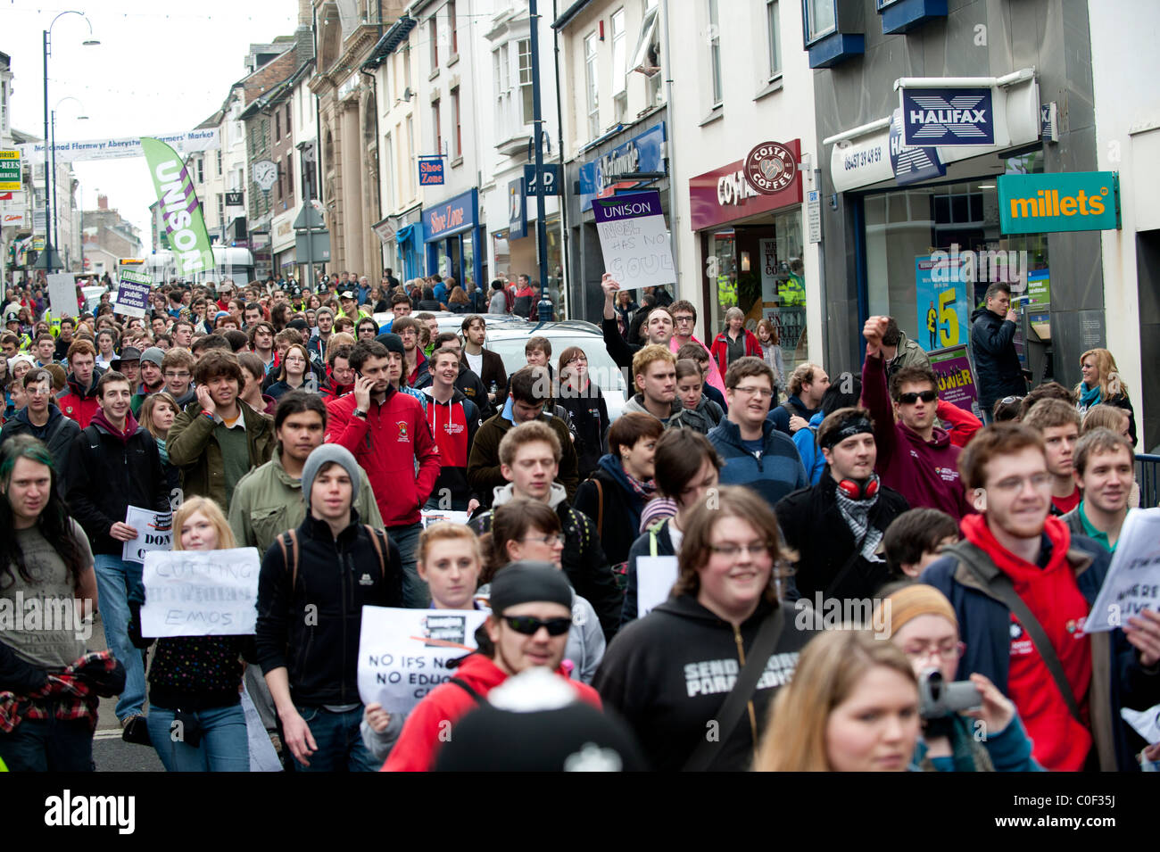 Cientos de estudiantes de la universidad de Aberystwyth marchan en protesta por los recortes en la financiación de la educación superior en el REINO UNIDO Foto de stock