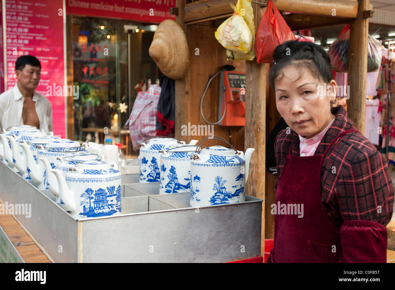 Dama de China en el mercado de Yangshuo ,vendiendo ollas de china azul y blanco Foto de stock