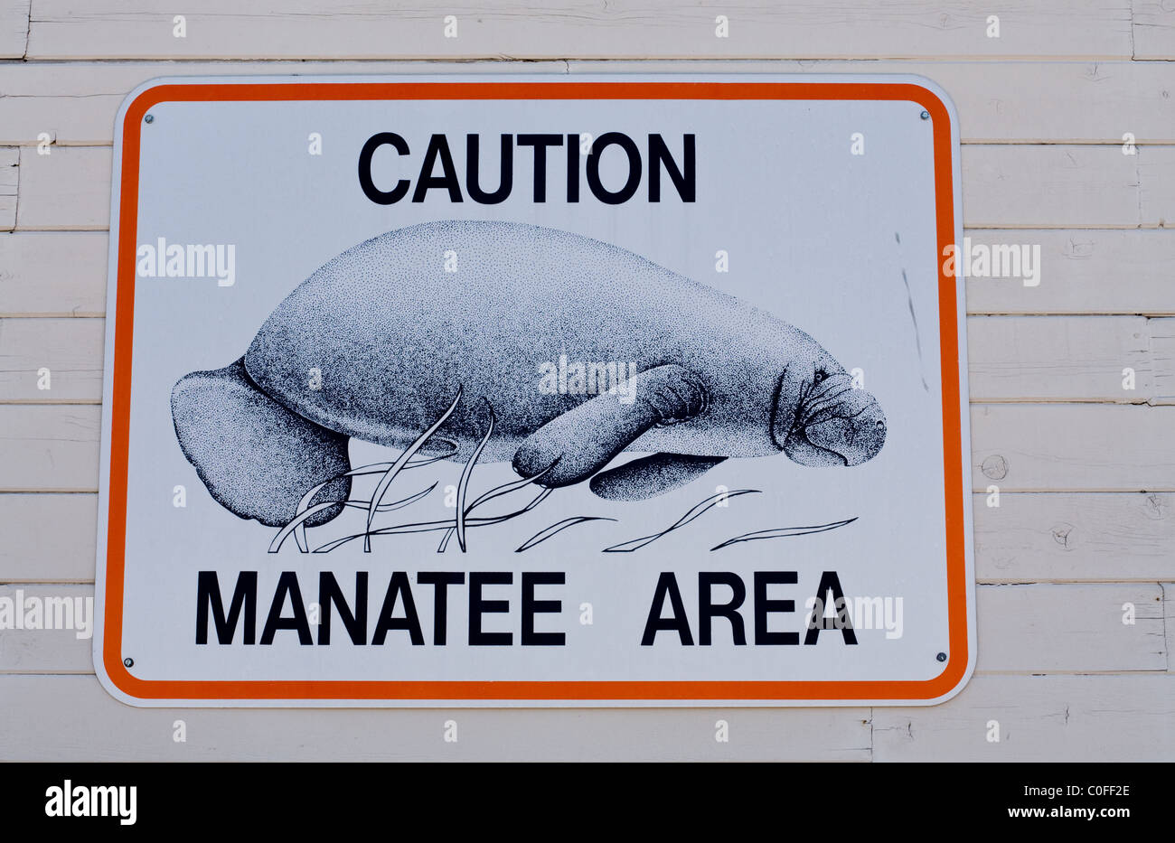 Señal de advertencia de área de manatíes en el lateral de un edificio Foto de stock