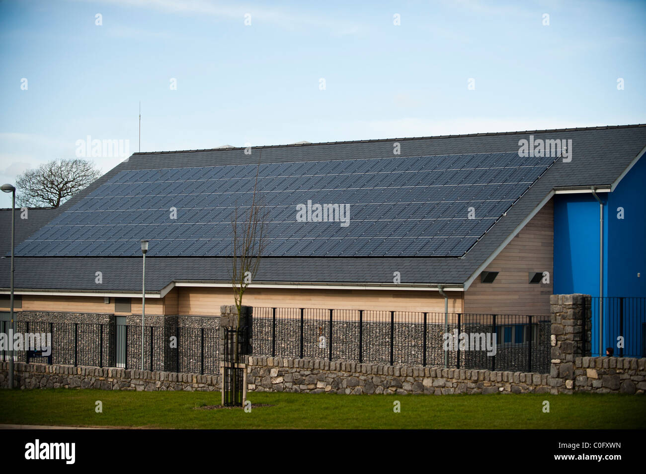 Los paneles solares fotovoltaicos en el techo de una escuela en Llangefni, al norte de Gales, Reino Unido Foto de stock