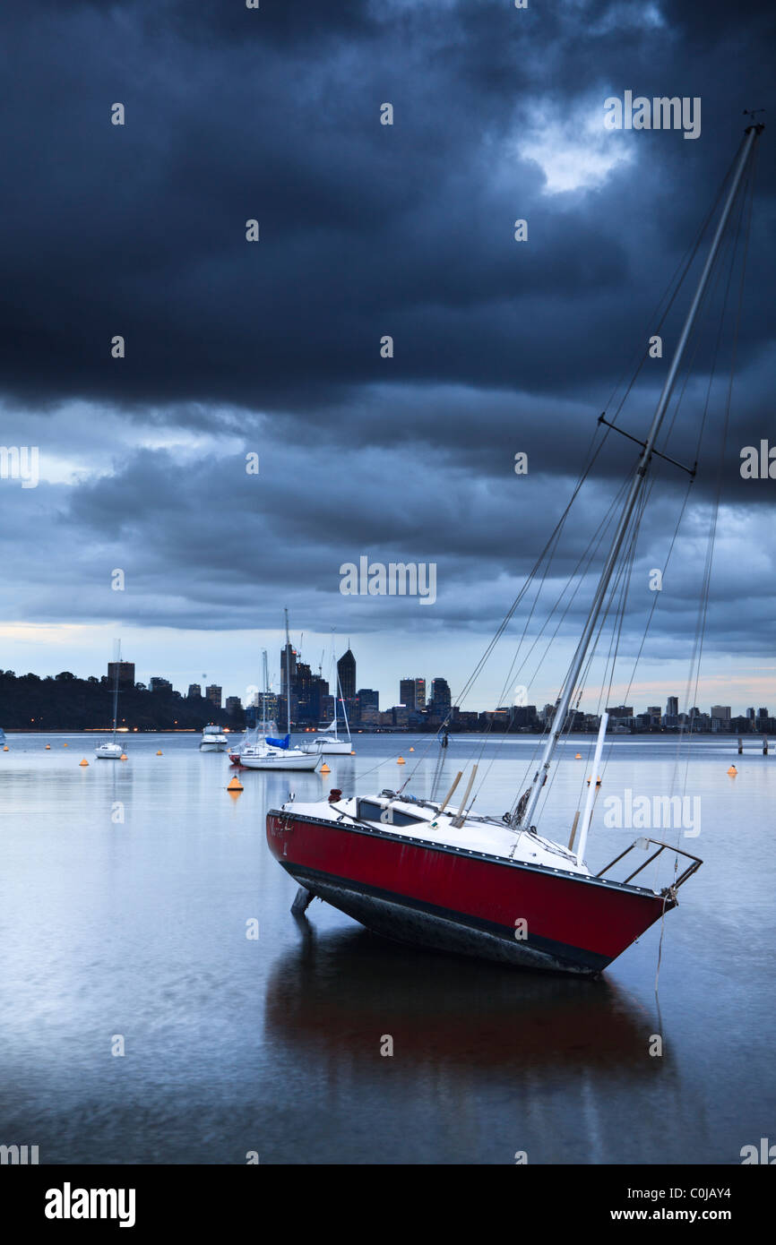 Yate atracado en el Matilda Bay en el Río Swan como nubes de tormenta se reúnen en Perth, Australia Occidental Foto de stock