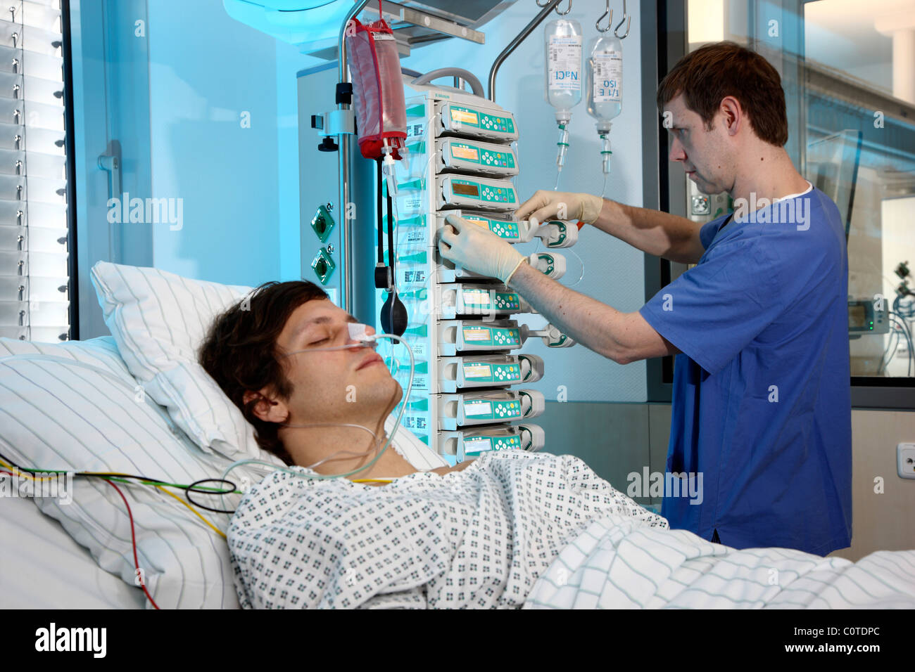 Unidad de cuidados intensivos de un hospital. Un paciente se conecta a diferentes sistemas de soporte de vida. Foto de stock